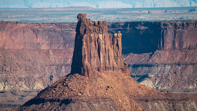 a tall sandstone tower with crumbled slopes beneath